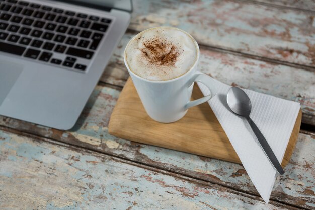 Tasse de café et cuillère avec ordinateur portable