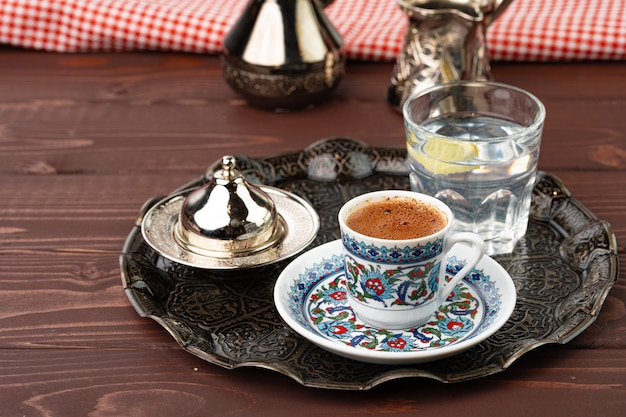 Tasse de café dans un style oriental sur plateau en métal se bouchent