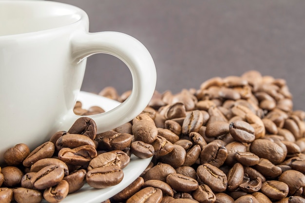 Tasse de café dans une tasse blanche et grains de café