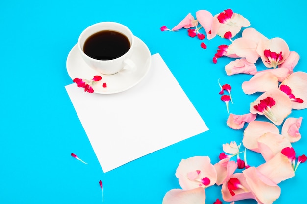 Tasse de café avec décor de fleurs sur table bleu clair. Concept d'amour et de romance.