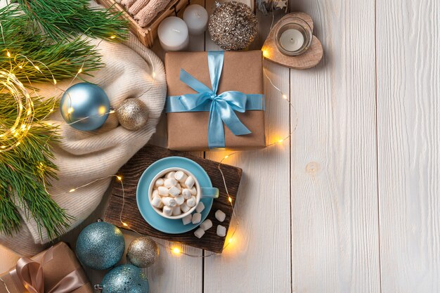 Une tasse de café avec des décorations de Noël de guimauves et un cadeau