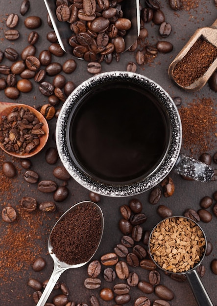 Tasse à café avec diverses boules de café moulu et en grains et granulés de café instantané lyophilisés sur fond marron Vue de dessus