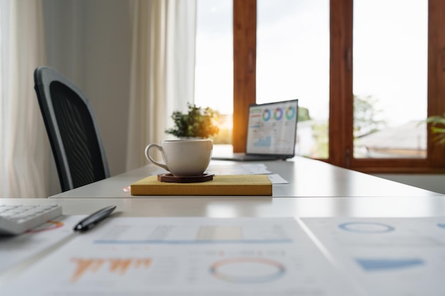 Tasse de café et documents financiers sur un bureau blanc au bureau