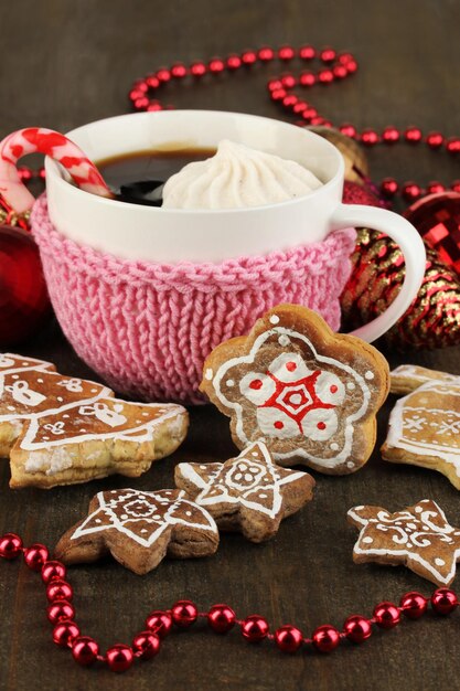 Tasse de café avec douceur de Noël sur table en bois close-up