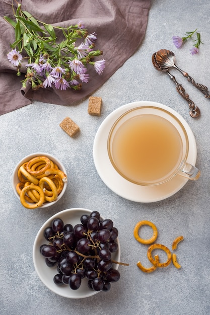 Tasse de café avec du lait et des craquelins sur la table grise.