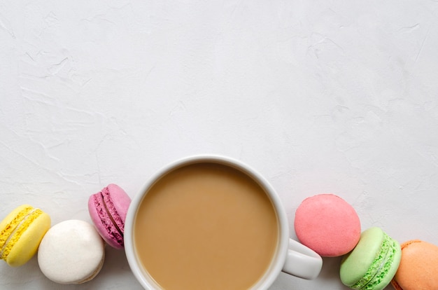 Une tasse de café avec du lait et des macarons