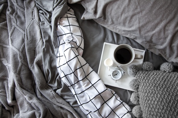 Tasse de café avec du lait sur un plateau au lit