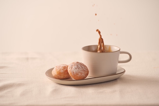 Tasse de café du matin et beignet sucré sur fond blanc