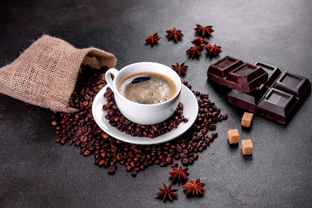 Une tasse de café du matin fraîchement parfumé pour bien démarrer la journée. Belle tasse de café avec du café sur une table sombre