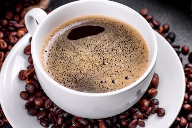 Une tasse de café du matin fraîchement parfumé pour bien démarrer la journée. Belle tasse de café avec du café sur une table sombre