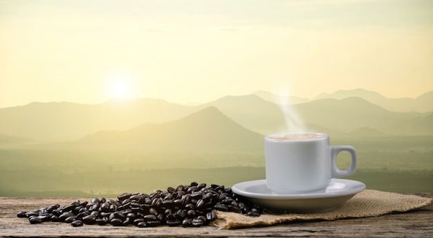 Tasse de café du matin et vue sur les grains de café torréfiés avec le soleil des montagnes