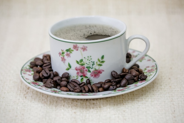 tasse à café avec du pain au fromage et des grains de café sur le côté