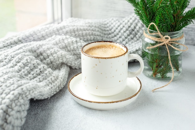 Tasse de café, écharpe et bouquet de branches de sapin