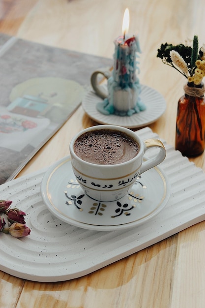 Une tasse de café est posée sur une assiette avec une fleur dessus.