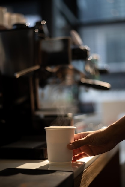 Une tasse de café est tenue par une personne.