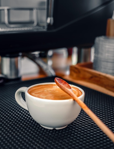 Une tasse de café expresso et une cuillère en bois sur le bar dans un café
