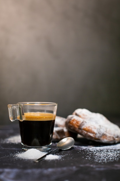 Photo tasse de café expresso avec deux croissants au chocolat et une couverture de sucre glace