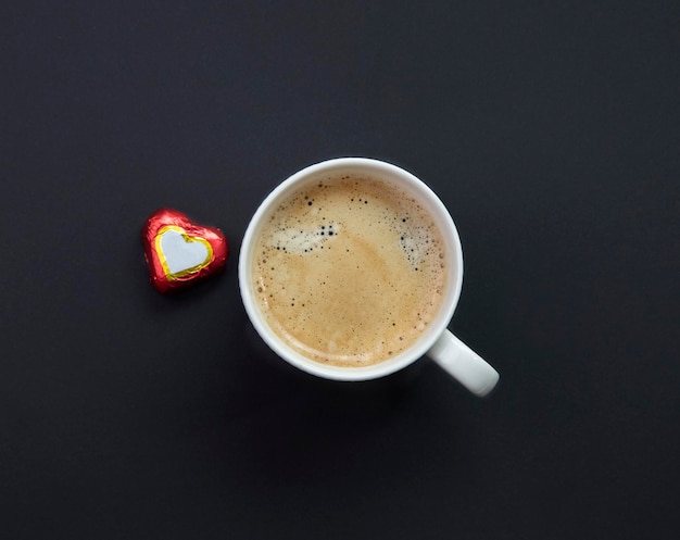 tasse de café expresso sur fond noir et coeur de bonbons