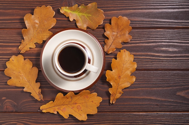 Tasse de café et feuilles d'automne jaunes