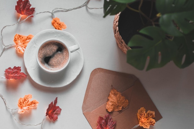 Tasse de café avec des feuilles de guirlande sur la table de chevet