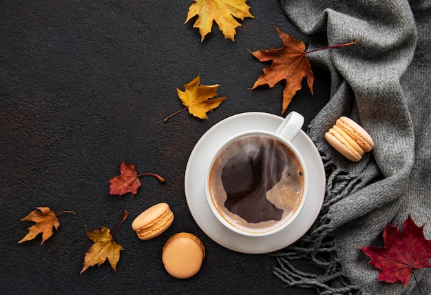 Tasse de café et feuilles sèches sur fond de béton noir. Mise à plat, vue de dessus, espace copie