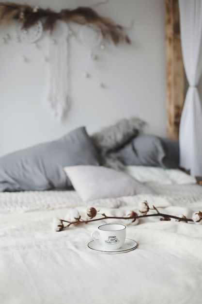 Photo tasse à café et fleur de coton. petit déjeuner au lit.