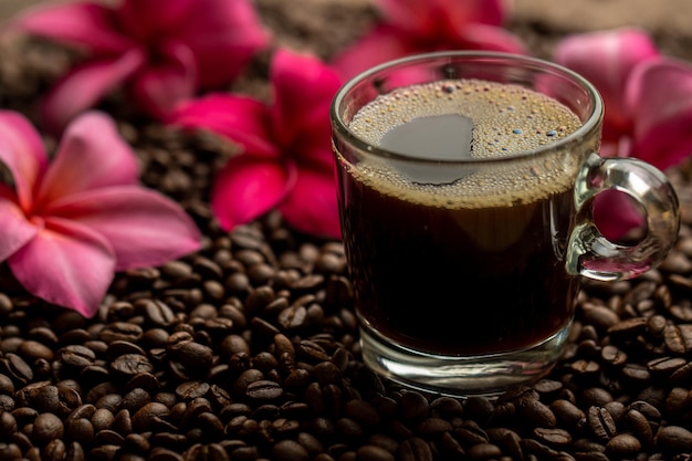 Une tasse de café avec des fleurs en arrière-plan