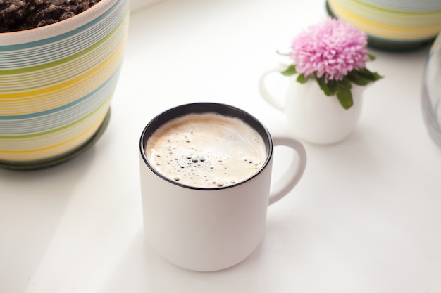 Une tasse de café et de fleurs d'aster - le concept d'un matin de printemps ou d'été, un style d'intérieur minimaliste