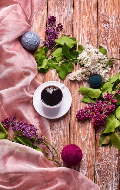 Tasse à café et fleurs lilas colorées sur table en bois de jardin