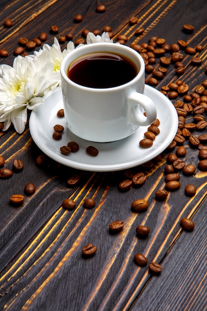 Tasse de café et fleurs sur table en bois foncé