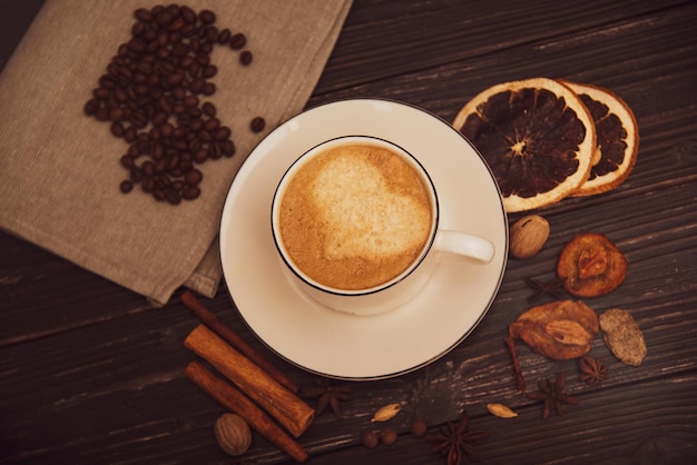 Une tasse de café sur un fond en bois avec des épices