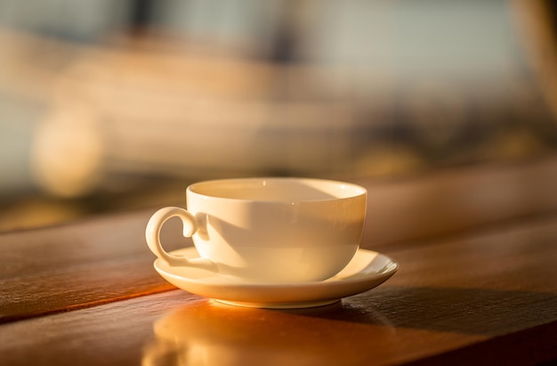 Tasse à café avec fond coucher de soleil sur table en bois