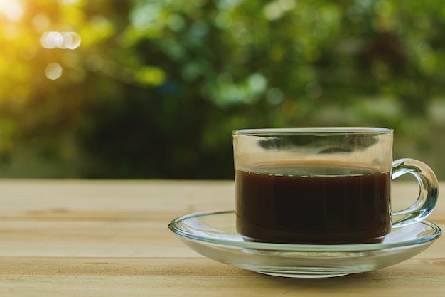 Une tasse de café sur fond naturel vert flou