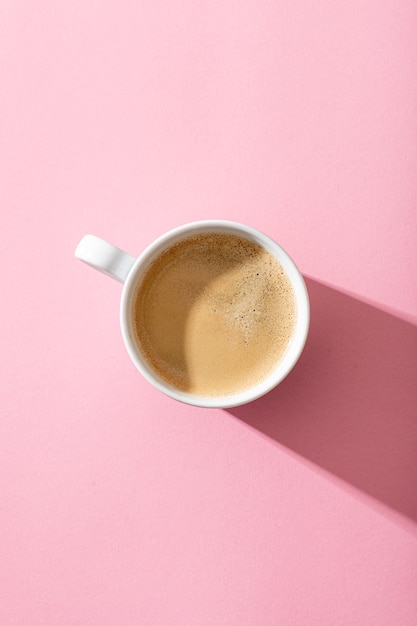 Une tasse de café sur fond rose