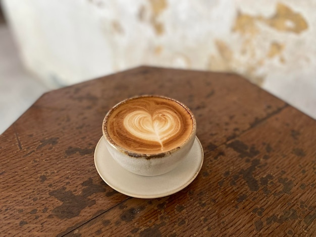 Une tasse de café avec une forme de coeur sur le dessus.