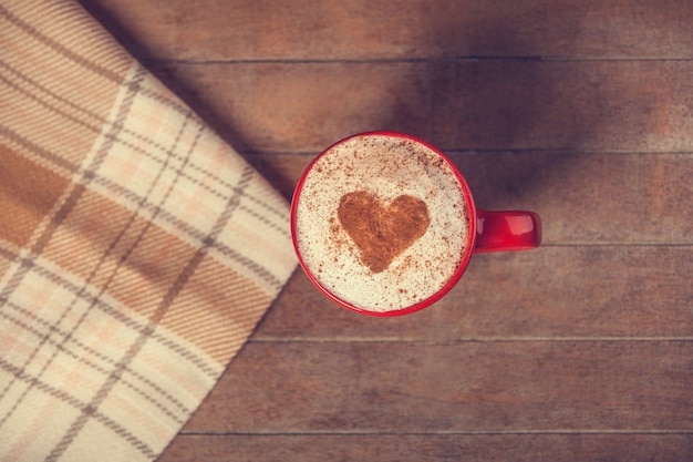Tasse avec café et forme du cœur de cacao dessus et écharpe