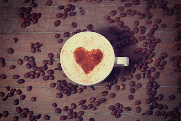 Tasse avec café et forme du coeur de cacao dessus.