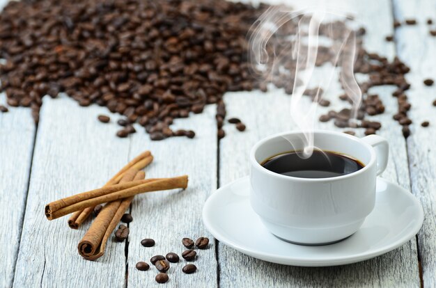 Photo tasse de café avec de la fumée et des grains de café autour