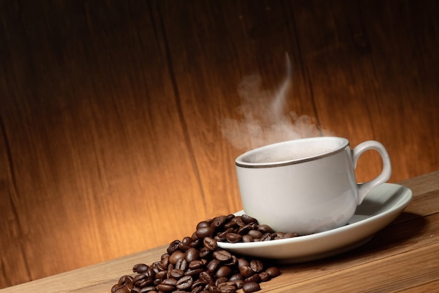 Tasse de café avec de la fumée et des haricots