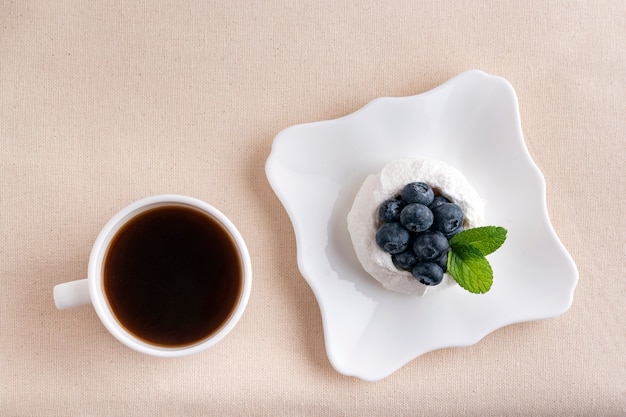 Tasse de café et gâteau aux baies de meringue. Vue de dessus. Petit déjeuner au lit.