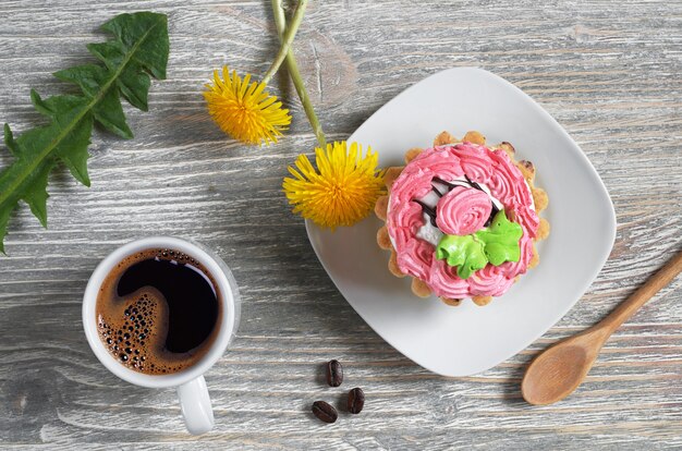 Tasse de café, gâteau et fleurs sur la vieille table en bois, vue du dessus