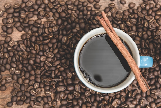 Tasse à café, grains de café et bâton de cannelle