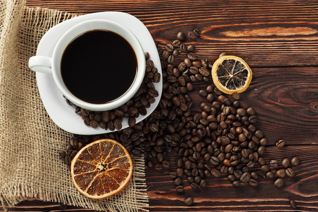 Tasse à café et grains de café sur bois