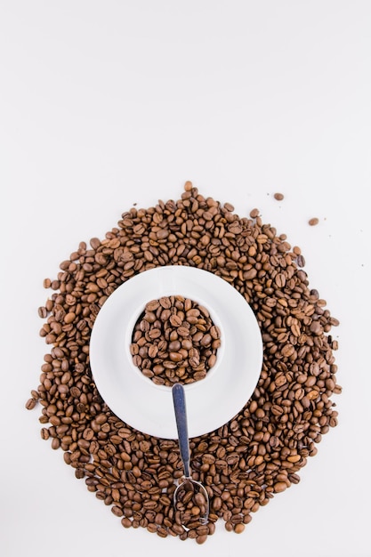 Tasse à café avec des grains de café sur fond blanc