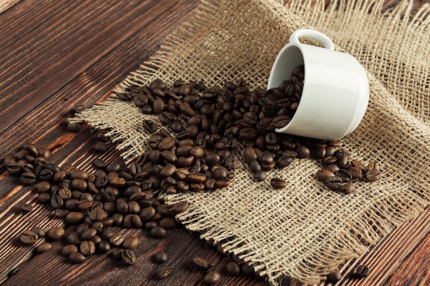 Tasse à café et grains de café sur fond en bois