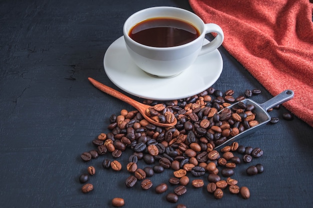 Tasse de café et de grains de café sur fond noir