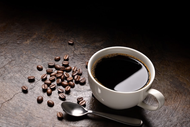 Tasse de café et grains de café sur fond rustique