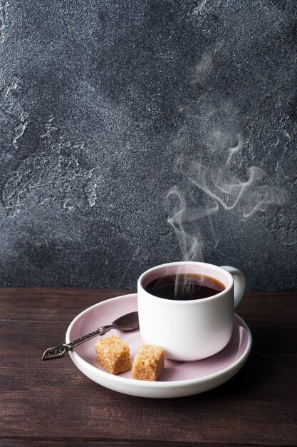 Tasse à café et grains de café sur fond sombre. Espace copie