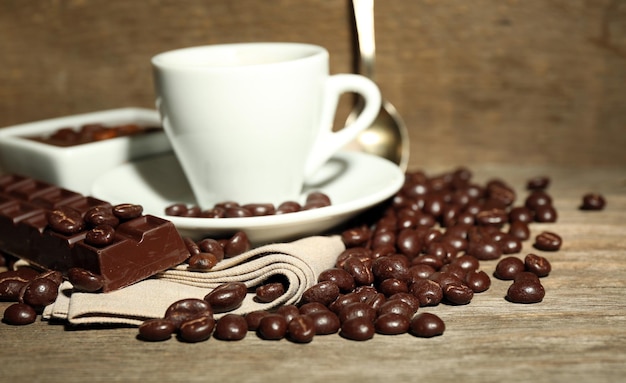 Tasse de café et de grains de café avec glaçage au chocolat sur fond de bois