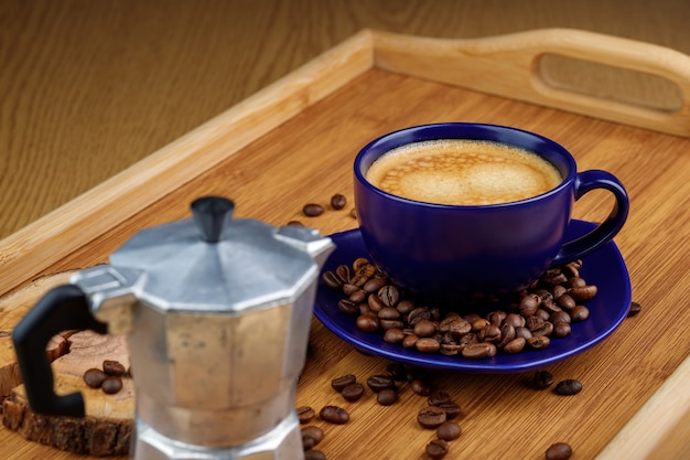 Tasse de café et de grains de café sur un plateau isolé